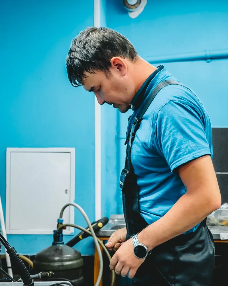A plumbing technician working with equipment